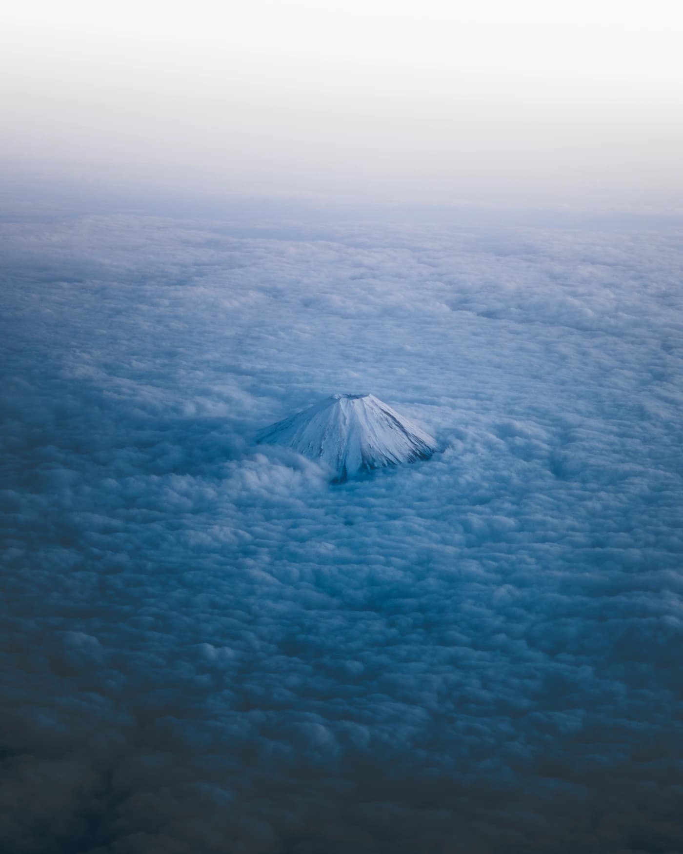 Snow-capped peak emerging above a sea of clouds