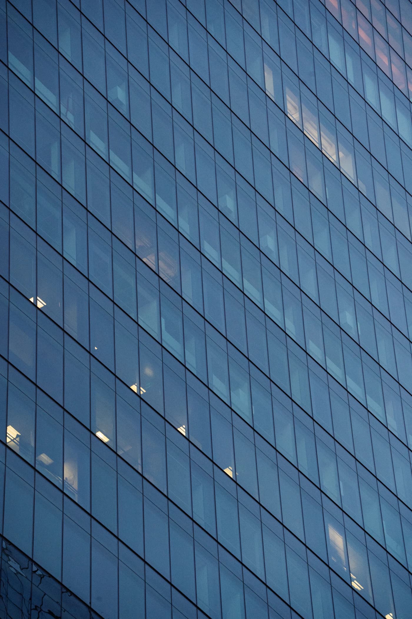 Modern glass office building reflecting the sky